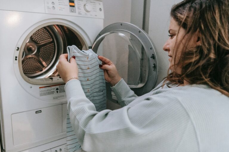 mulher colocando roupas na lavadora