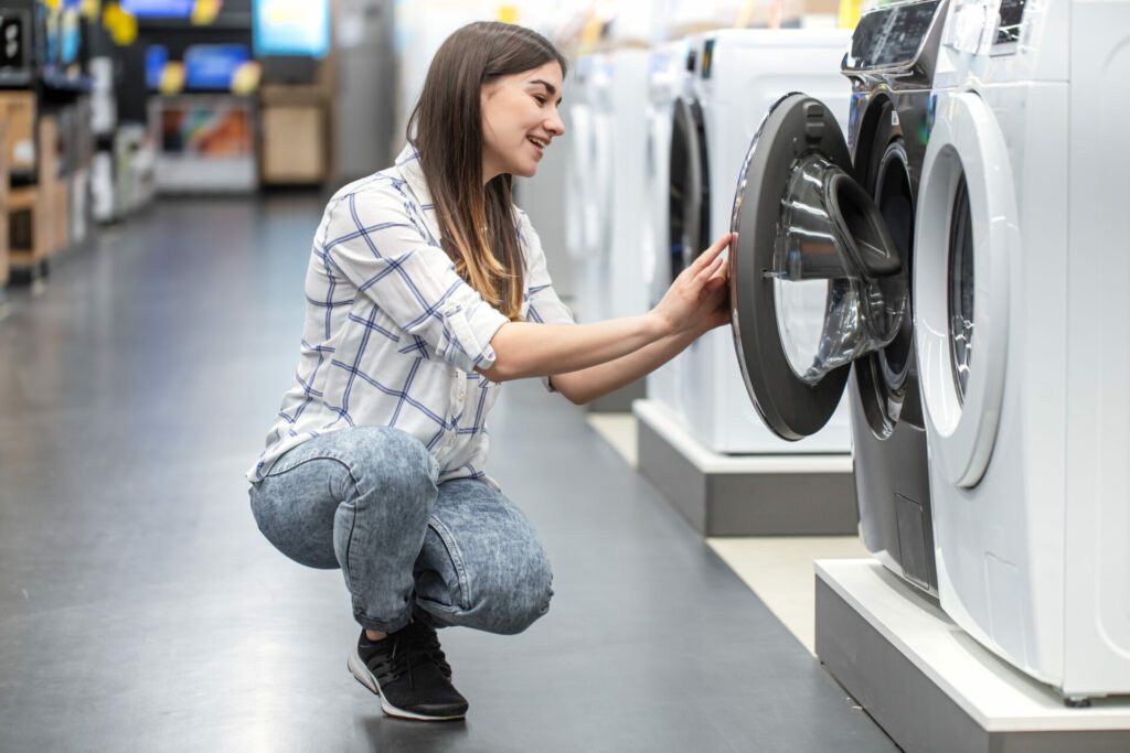 mulher jovem olhando para máquina de lavar